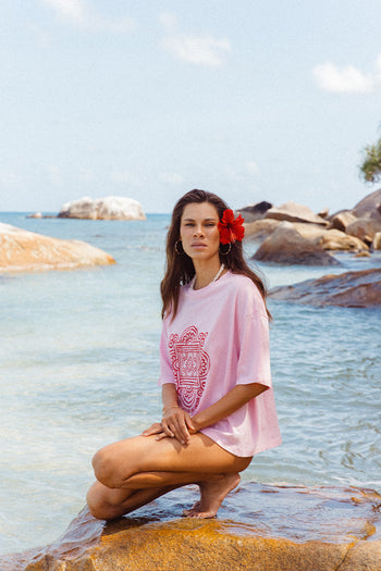 Shanti Tee Pink — back view at beach, pink oversized cotton tee showing clean back and oversized fit, ocean and rocks backdrop | Daughters of India